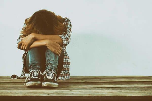 Photo of person holding knees showing despair
