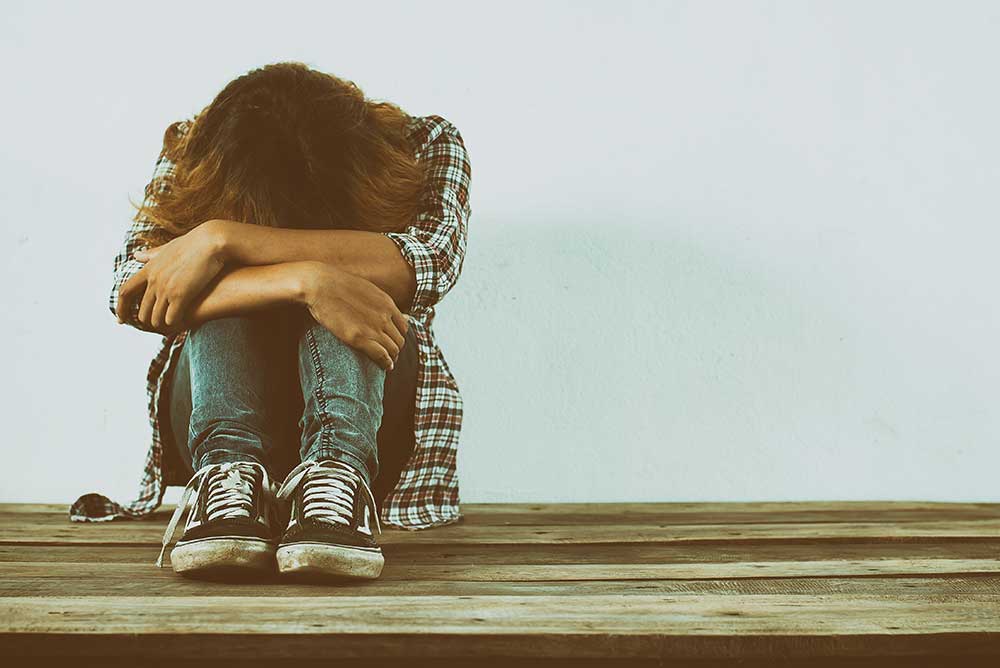 Photo of person holding knees showing despair