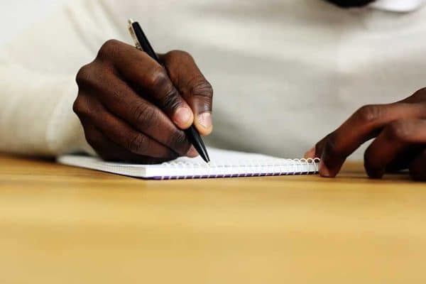 person writing with a pen on paper