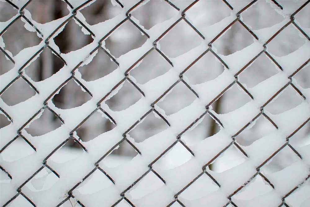 image of chain link metal fence with snow