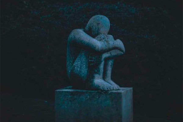 Photo of statue of person curled in a ball