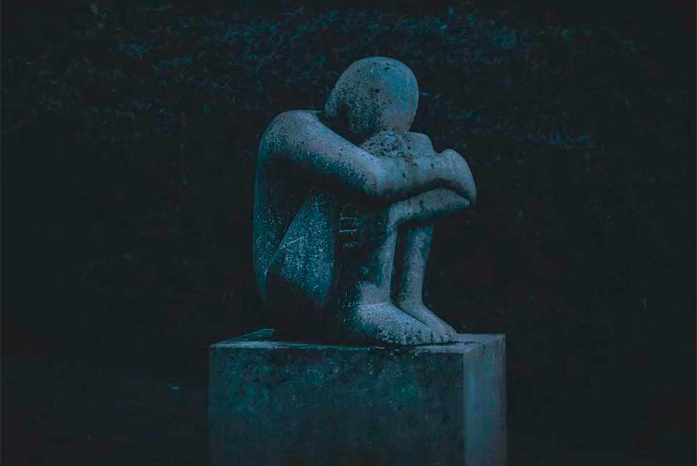 Photo of statue of person curled in a ball